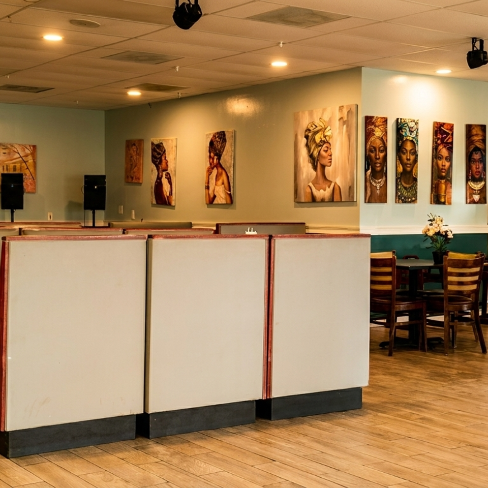Restaurant interior with booths, tables, chairs, and diverse artwork on light blue walls.
