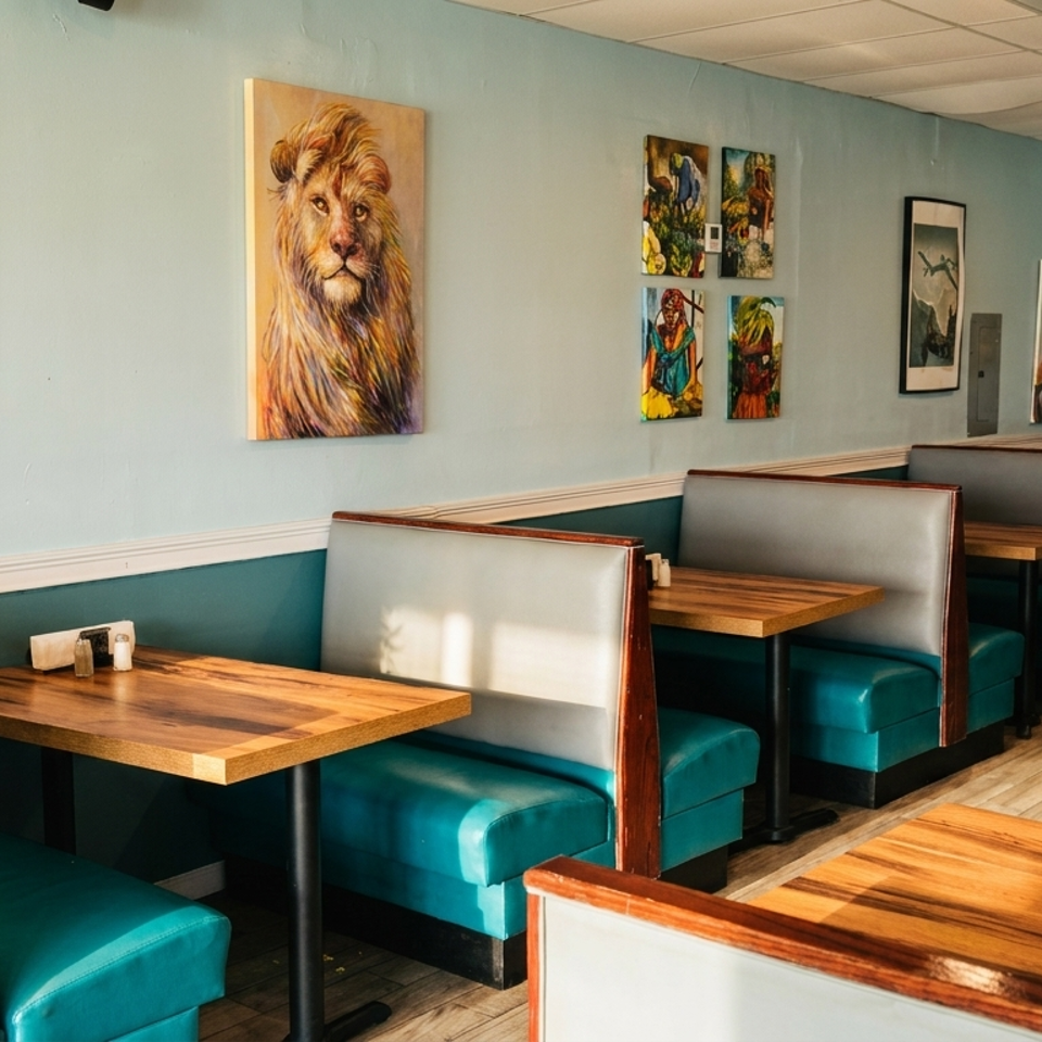 Restaurant interior with teal booths, light blue walls, and diverse artwork, including a large portrait.